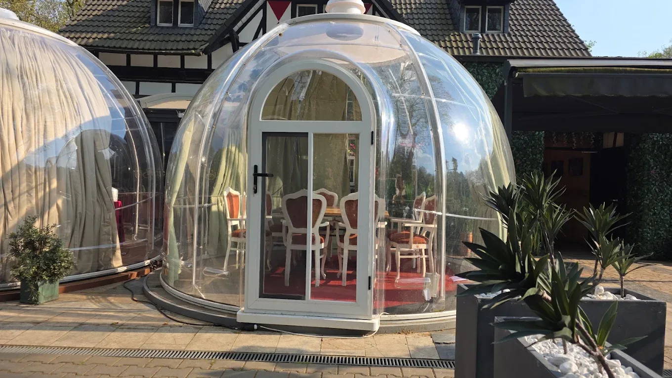 Gedeckter Tisch in einer Glaskuppel auf der Terrasse