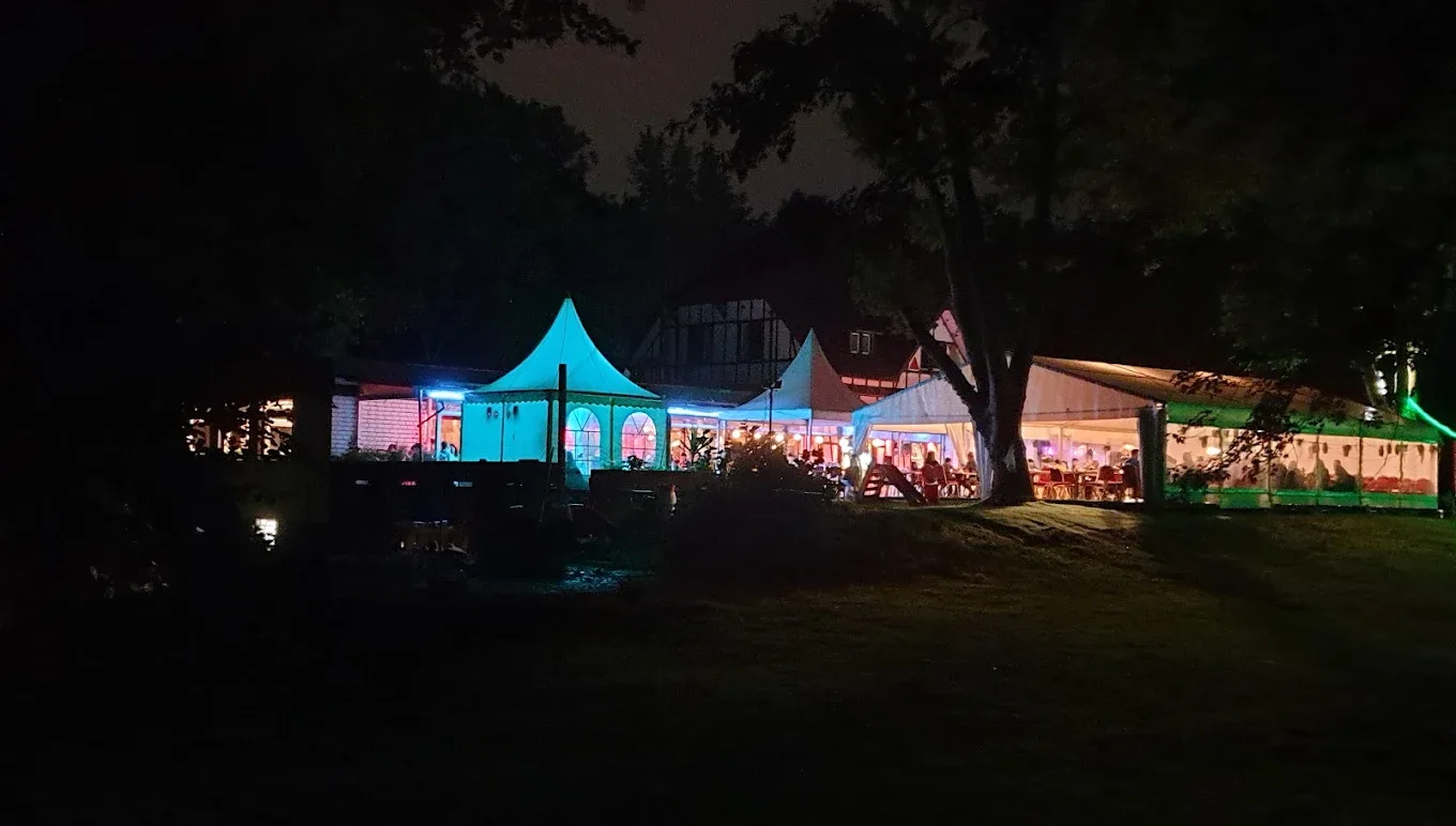 Lounge-Terrasse am Abend mit beleuchteten Zelten im Garten